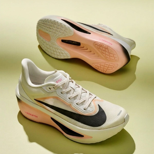Pair of running shoes with pink and black accents on a light green background