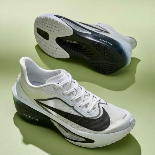 White and black running shoes on a green background